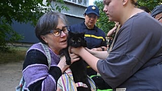 Eine Frau trägt ihre Katze aus einem beschädigten Mehrfamilienhaus nach Russlands massivem Luftangriff in Odesa, Ukraine, am Donnerstag, den 3. Juli 2025.