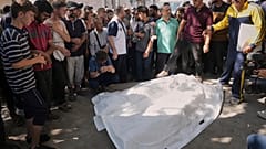 فلسطينيون يتجمعون حول جثث الدكتور مروان سلطان مدير المستشفى الإندونيسي في شمال قطاع غزة وزوجته وابنته وصهره بعد قتلهم في غارة جوية إسرائيلية على مستشفى الشفاء في مدينة غزة