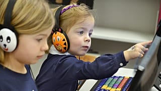 Evalie Mandura, 6 ans, et sa sœur, Elizabeth, 3 ans, jouaent à des jeux éducatifs sur des ordinateurs, le mercredi 29 janvier 2014, à Marion, Indiana.