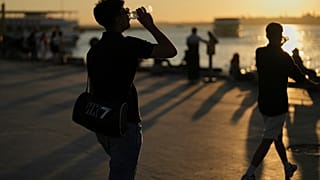 Emberek vizet isznak egy forró nyári napon a Kadikoy tengerparti sétányon Isztambulban, Törökországban, 2025. július 2-án, szerdán.
