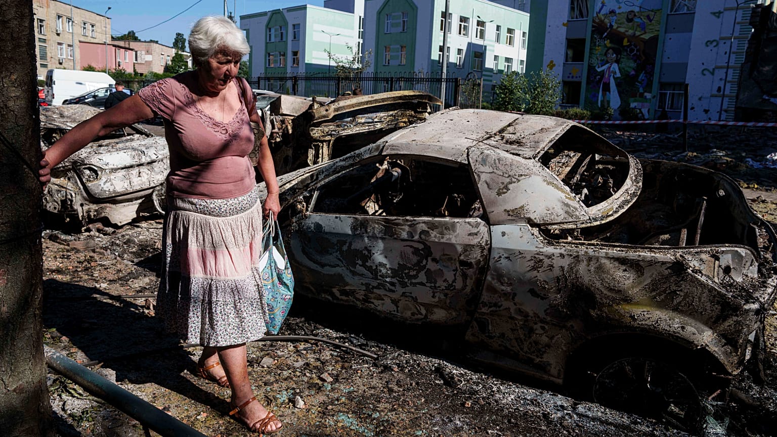 Una mujer pasa junto a coches destruidos por un ataque ruso en Kiev, Ucrania, el viernes 4 de julio de 2025