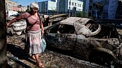 Eine Anwohnerin geht am Freitag, den 4. Juli 2025, an von einem russischen Angriff zerstörten Autos in Kyjiw, Ukraine, vorbei.