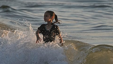 A Palestinian girl cools off in the Mediterranean Sea during a heat wave in Gaza City, Wednesday, July 2, 2025.