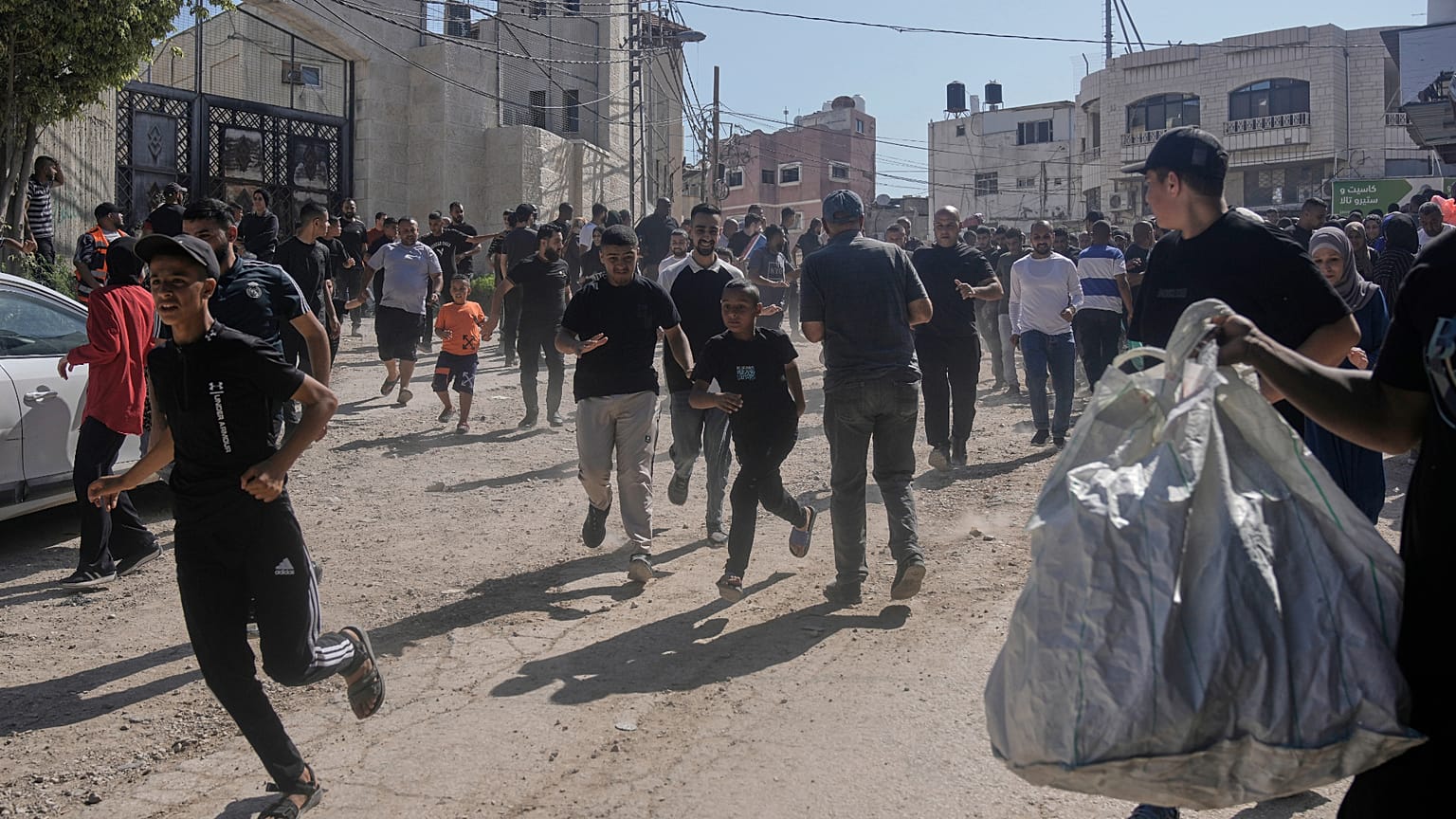 Refugiados palestinos corriendo en un campo.