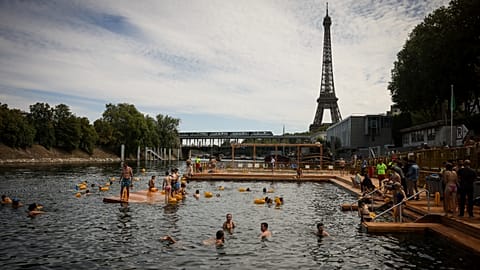 People swim at the Grenelle safe bathing site on the Seine river in Paris, France, Saturday, July 5, 2025, during the opening of the three Seine swimming pools