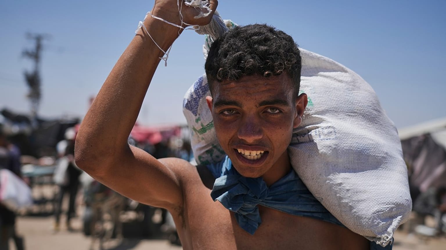 فلسطينيون يحملون طرودًا غذائية ومساعدات إنسانية سلمتها "مؤسسة غزة الإنسانية"، في رفح، جنوب قطاع غزة، الخميس 26 يونيو/حزيران 2025.  