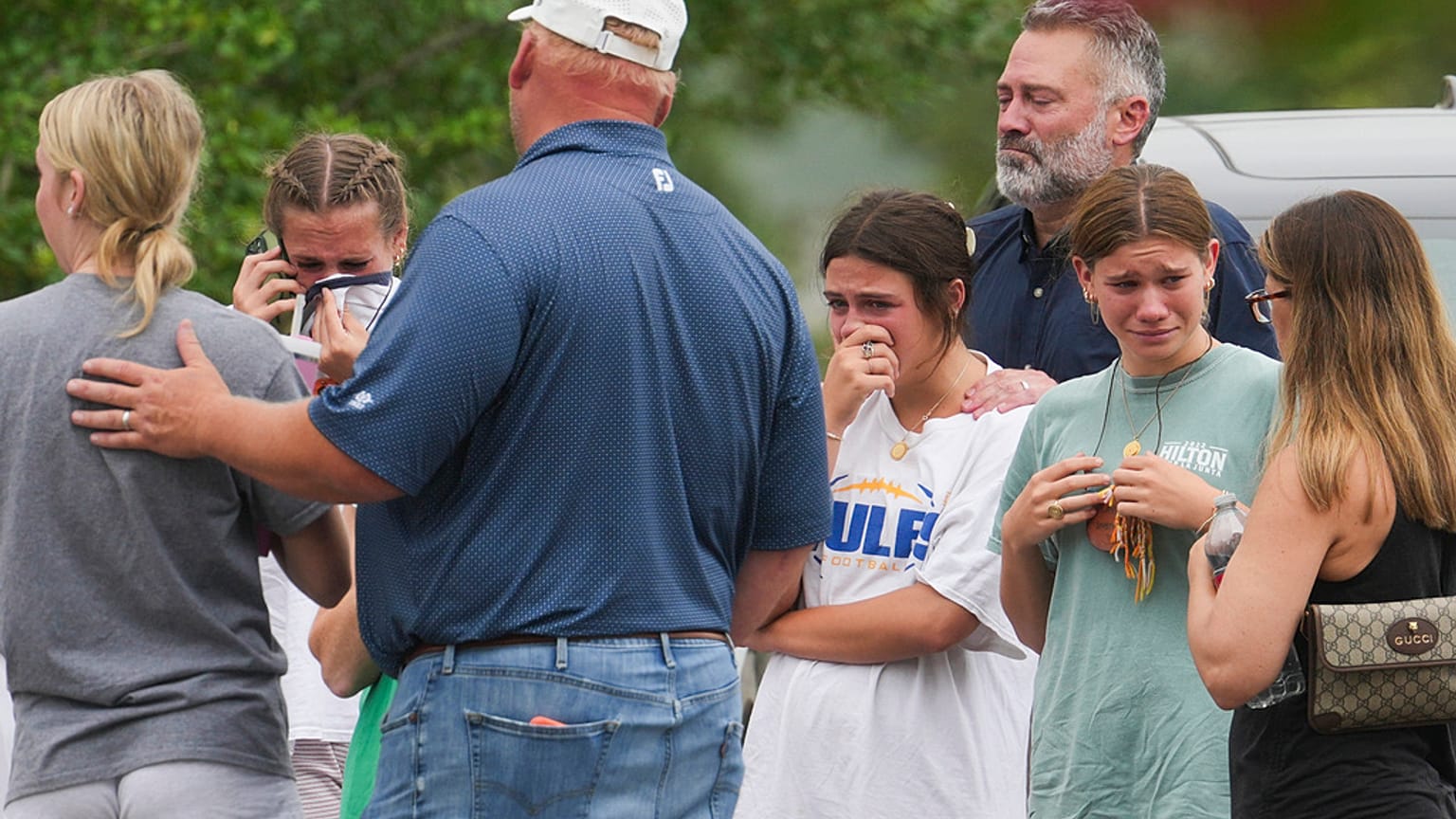 People comfort each other outside the Butt-Holdsworth Memorial Library in Kerville after heavy rainfall caused the Guadalupe River to flood 