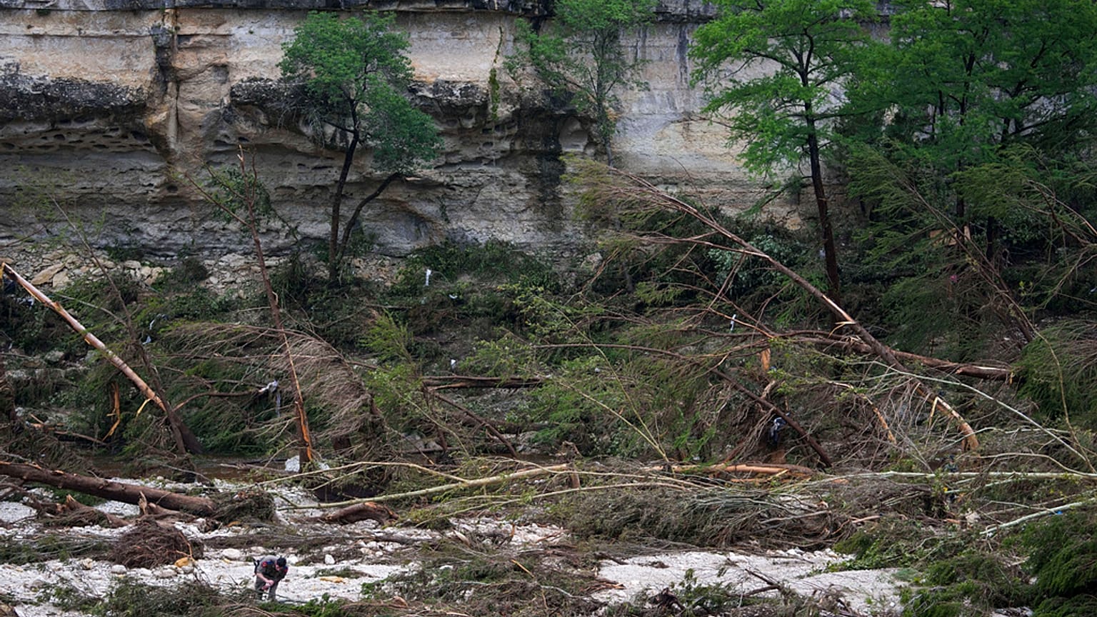 Ein Sicherheitsbeamter durchkämmt die Ufer des Guadalupe River, nachdem eine Sturzflut am Samstag, dem 5. Juli 2025, in Hunt, Texas, über das Gebiet hinweggefegt ist. 
