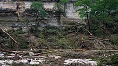 Ein Sicherheitsbeamter durchkämmt die Ufer des Guadalupe River, nachdem eine Sturzflut am Samstag, dem 5. Juli 2025, in Hunt, Texas, über das Gebiet hinweggefegt ist. 