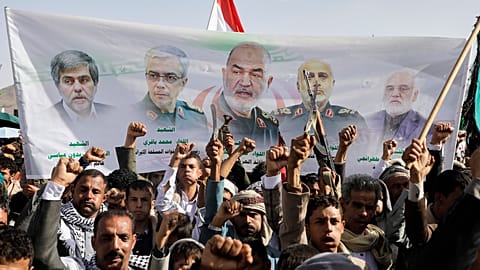 Houthi támogatók jelszavakat skandálnak, miközben egy transzparenst emelnek, amelyen iráni vezetők láthatóak, akiket izraeli csapások során öltek meg a jemeni Szanaában, 2025. június 13-án, pénteken.