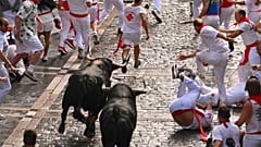 يركض المحتفلون مع الثيران من مزرعة فوينتي يمبرو خلال اليوم الأول من سباق الثيران في مهرجان سان فيرمين في بامبلونا، إسبانيا، يوم الاثنين 7 يوليو 2025.  