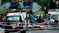 DOSSIER - L'épave d'un bus à impériale dont le toit a été arraché par une bombe et des voitures endommagées sont éparpillées sur la route à Tavistock Square, dans le centre de Londres, le 7 juillet 2005.