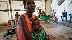 سيدة من جنوب السودان تحمل ابنتها الرضيعة التي تعاني من سوء التغذية الحاد في منطقة فنجاك القديمة في ولاية جونقلي بجنوب السودان يوم الثلاثاء، 28 ديسمبر/كانون الأول 2021