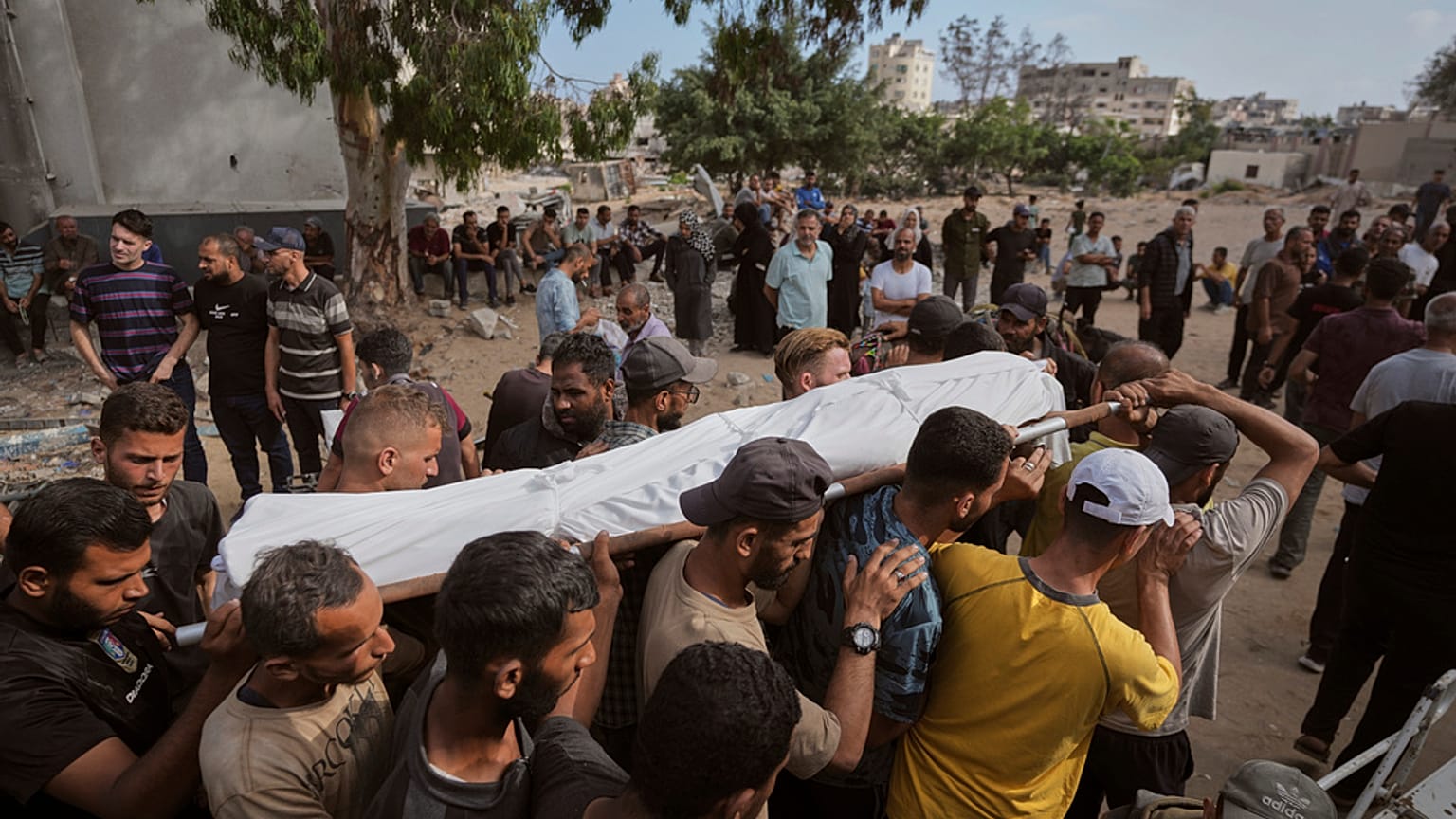يحمل المشيعون جثمان رجل فلسطيني قُتل أثناء توجهه إلى مركز توزيع المساعدات، خلال جنازته في مدينة غزة