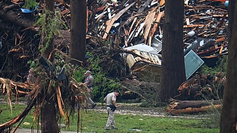 Officials comb through the banks of the Guadalupe River after a flash flood swept through the area Saturday, July 5, 2025, in Hunt, Texas