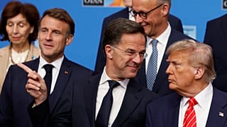 O Presidente Donald Trump, à direita, fala com o Secretário-Geral da NATO, Mark Rutte, durante uma fotografia de grupo dos Chefes de Estado e de Governo da NATO na Cimeira da NATO em Haia