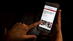 Una mujer lee un artículo en su teléfono móvil sobre las posibilidades de las noticias falsas.