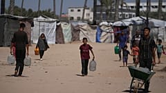 Παλαιστίνιοι μεταφέρουν δοχεία με νερό σε καταυλισμό εκτοπισμένων στη Ντέιρ αλ Μπαλάχ στη Λωρίδα της Γάζας, Δευτέρα, 7 Ιουλίου 2025.  