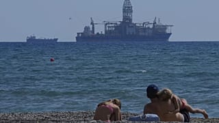 Eine Familie sitzt am Meer mit Blick auf das Bohrschiff "Tungsten Explored" in der südlichen Küstenstadt Larnaca, Zypern, 3. November 2021. 