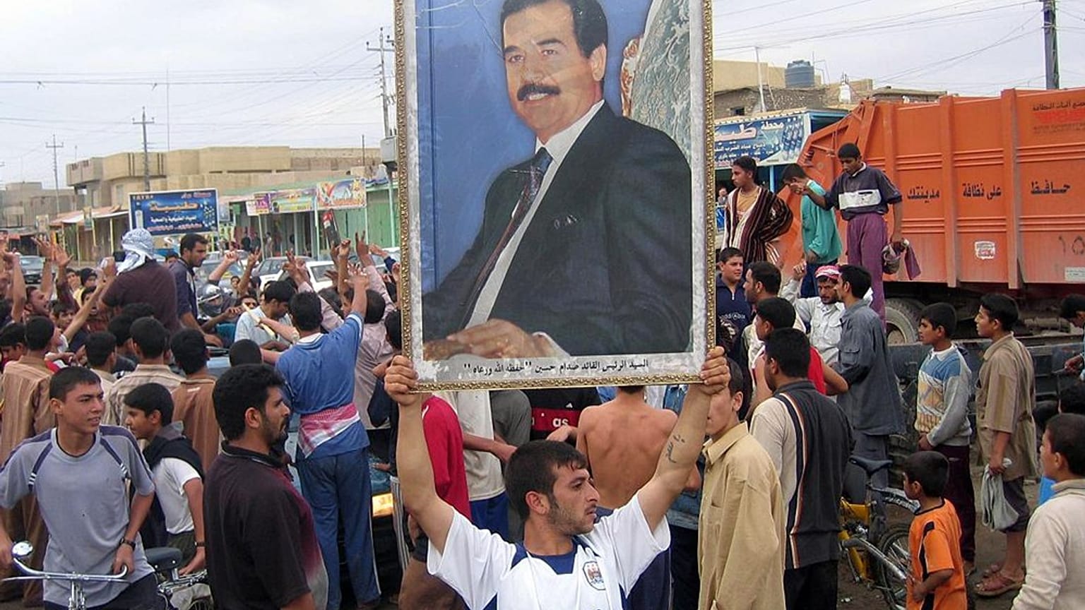 رجل يرفع صورة  للرئيس العراقي المخلوع صدام حسين احتجاجًا على حكم إعدامه في الفلوجة، العراق، يوم الاثنين 6 نوفمبر/تشرين الثاني 2006.  