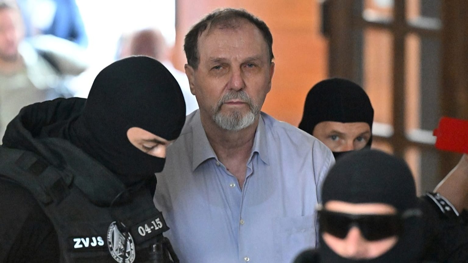 Juraj Cintula, ortada, 8 Temmuz 2025 Salı günü Slovakya, Banská Bystrica'daki İhtisas Ceza Mahkemesi'ne götürülüyor