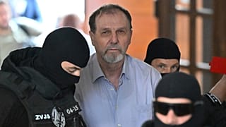 Juraj Cintula, ao centro, é escoltado até ao Tribunal Penal Especializado em Banská Bystrica, Eslováquia, terça-feira, 8 de julho de 2025