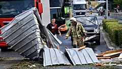 Ein Feuerwehrmann räumt am Dienstag, den 8. Juli 2025, Trümmer von einer Straße in Split, Kroatien, nach einem heftigen Sturm weg.