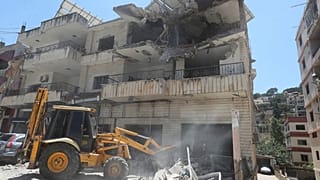 جرافة تزيل الأنقاض بالقرب من مبنى مدمر أصيب في غارة جوية إسرائيلية في بلدة النبطية، جنوب لبنان، الجمعة 27 يونيو/حزيران 2025.