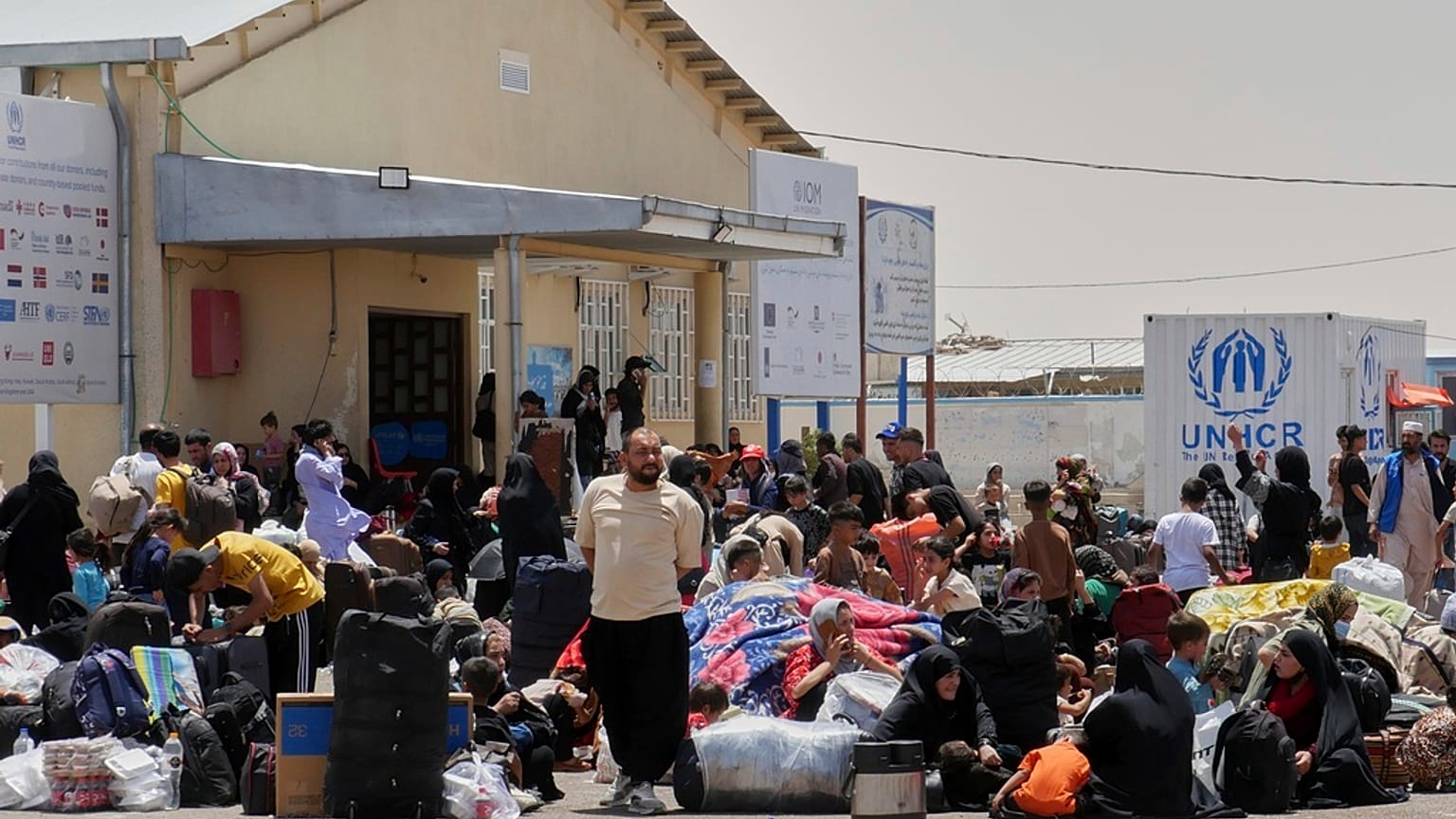 لاجئون أفغان عائدون من إيران يتجمعون قرب معبر إسلام قلعة في ولاية هرات، 20 حزيران/ يونيو 2025.    