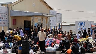 لاجئون أفغان عائدون من إيران يتجمعون قرب معبر إسلام قلعة في ولاية هرات، 20 حزيران/ يونيو 2025.
