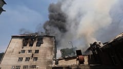 Rettungskräfte löschen am Montag, den 7. Juli 2025, in Saporischschja, Ukraine, ein Feuer in einem Gebäude, das durch einen russischen Drohnenangriff zerstört wurde.