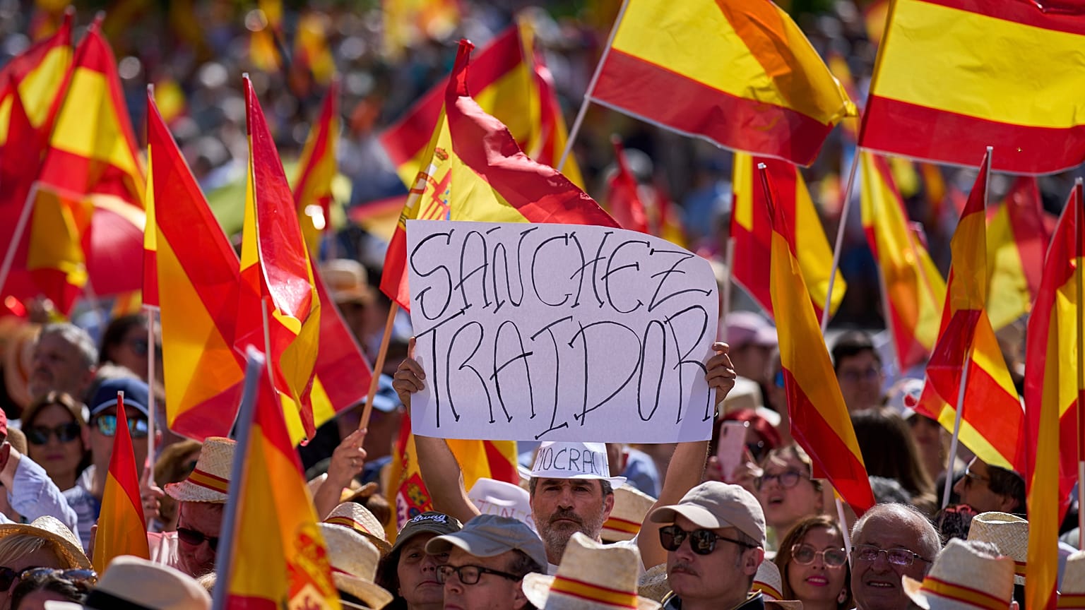Madrid'de Başbakan Pedro Sánchez hükümetine karşı düzenlenen miting sırasında bir protestocu "Hain Sanchez" yazılı bir pankart tutuyor, 8 Haziran, 2025
