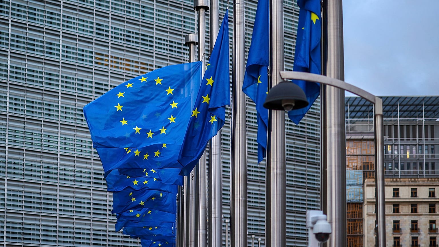 Flagi Unii Europejskiej powiewają na wietrze w połowie kadru przed siedzibą UE w Brukseli, piątek, 9 września 2022 r. 