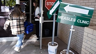 Trabalhadores da saúde entram numa clínica de sarampo no Texas, a 8 de abril de 2025.