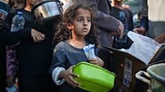 طفلة فلسطينية تقف في طابور للحصول على الطعام في دير البلح، قطاع غزة