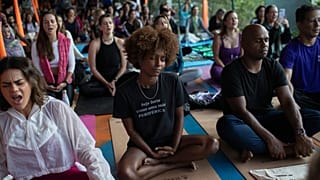 Une femme assise en position du lotus médite lors d'un cours de yoga du Projet de Transformation dans la favela Rocinha, à Rio de Janeiro, le mercredi 9 juillet 2025