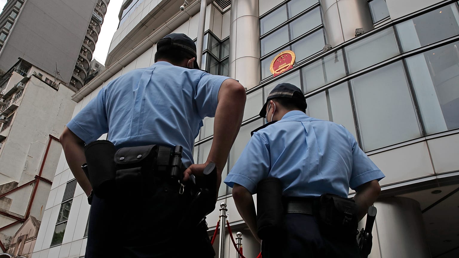 Polis memurları Çin'in Hong Kong'daki yeni Ulusal Güvenliği Koruma Ofisi'nin önünde nöbet tutuyor, 8 Temmuz, 2020