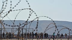 Migranten, die südlich von Kreta gerettet wurden, gehen nach ihrer Ankunft im Hafen von Lavrio zu Fuß, 10. Juli 2025