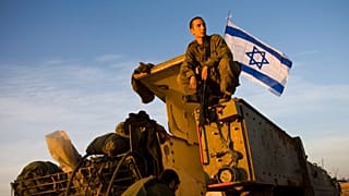 Un soldado israelí sentado sobre un vehículo blindado cerca de la frontera de Gaza, en el sur de Israel, 15 de enero de 2009.
