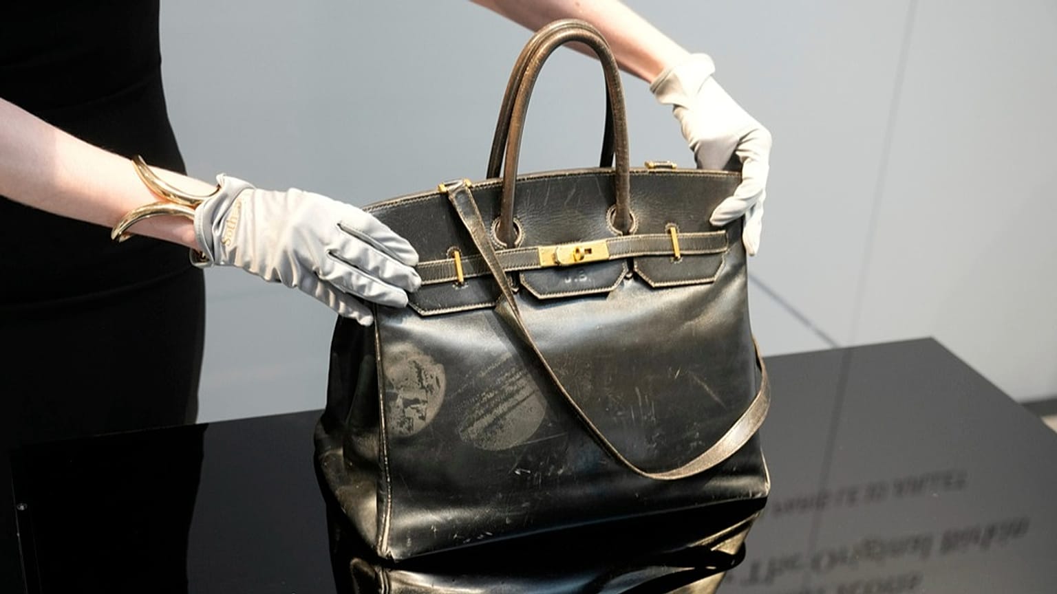 Oficer aukcyjny pokazuje oryginalną torebkę Birkin stworzoną przez Hermès dla Jane Birkin w 1984 roku, przed aukcją w czwartek, 10 lipca 2025 roku w Paryżu.