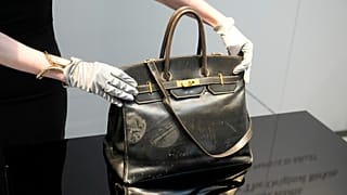 Un subastador muestra el bolso Birkin original creado por Hermès para Jane Birkin en 1984, antes de su subasta el jueves 10 de julio de 2025 en París.