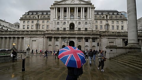  A woman with an umbrella stands in front of the Bank of England, at the financial district in London. 3 November 2022.