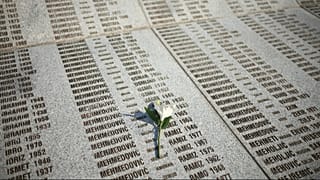 Una flor se ve en un monumento con los nombres de los asesinados en el genocidio de Srebrenica, en el Centro Memorial en Potocari, Bosnia, viernes 11 de julio de 2025.