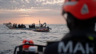 Szenegáli tengerészek közelednek a halászok csónakjához, hogy ellenőrizzék a migráns csónakok keresésére irányuló küldetés során Dakar partjainak közelében, 2024. november 16-án.