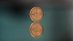 Ein Bitcoin-Token wird für ein Foto in Prag, Tschechische Republik, am 11. Mai 2025 auf einen Spiegel gelegt.