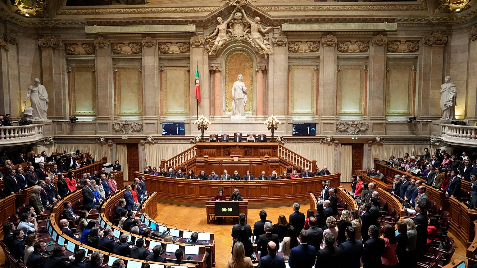 ARQUIVO: Os deputados dos partidos da oposição levantam-se para votar contra uma moção de confiança no Governo no Parlamento português, em Lisboa