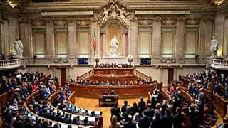 ARQUIVO: Os deputados dos partidos da oposição levantam-se para votar contra uma moção de confiança no Governo no Parlamento português, em Lisboa