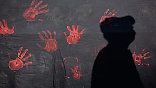 A man casts a shadow on a banner during a demonstration to denounce violence against women in Lisbon, 1 June, 2016