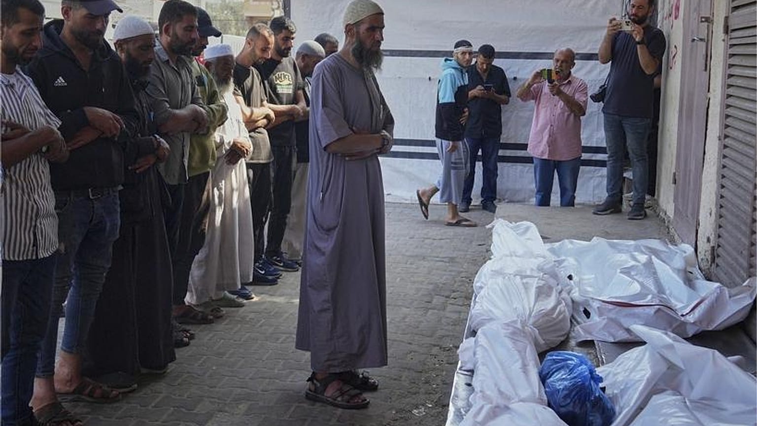 فلسطينيون يصلون على جثث أشخاص قتلوا في غارات إسرائيلية في غزة