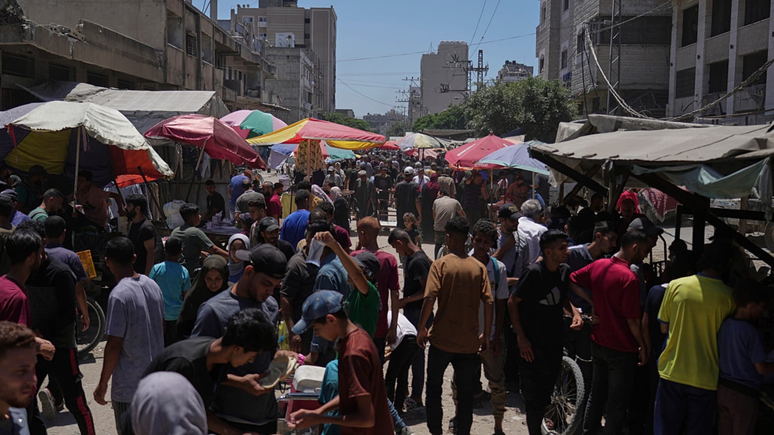Ludzie spacerują po targu Al-Sahaba w centrum miasta Gaza w środę, 9 lipca 2025 r. 